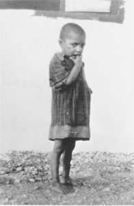A Romani child interned in the Rivesaltes transit camp in France. The original caption reads, “A Gypsy child who loves to dance on tables,” 1941-1942. Photo credit: USHMM #17729