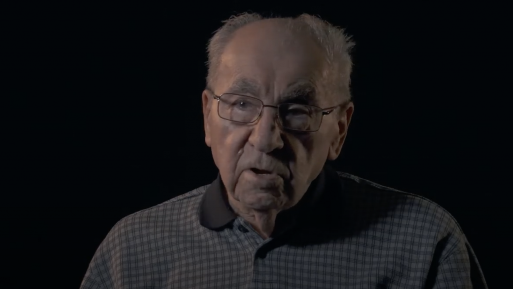 Image still of a Holocaust survivor from KHC Concentration Camps Exhibit Preview Film #1: available on QCC's YouTube channel