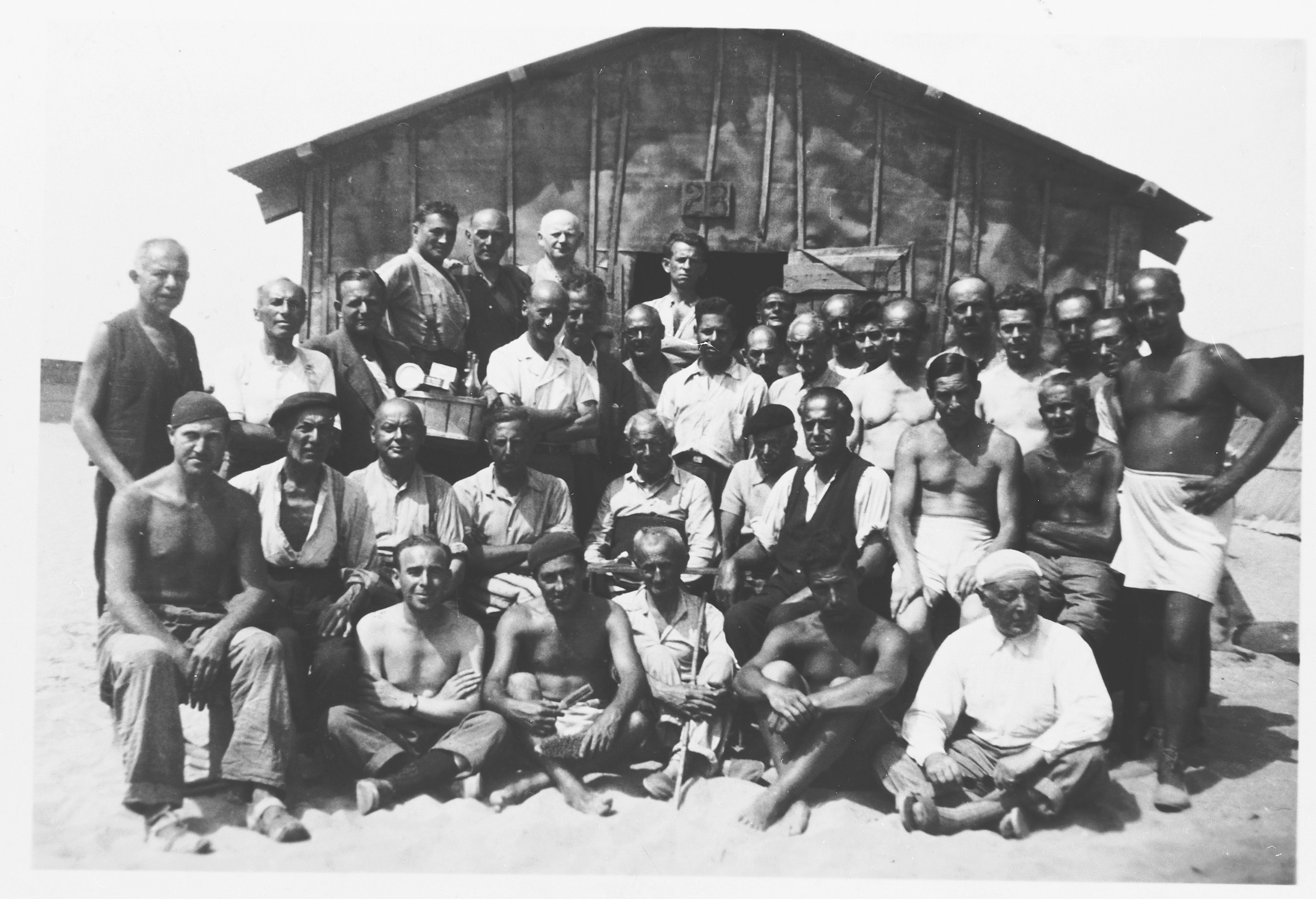 Prisoners pose in front of a barrack
