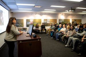 Image of Danyelle Means, co-curator of "Survivance on Turtle Island" speaking to audience about the exhibit, 2019