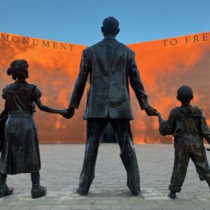 Sculpture of father, daughter, and son in front of the Monument to Freedom inside the Freedom Monument Sculpture Park in Montgomery, Alabama